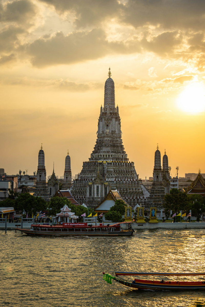 Wat Arun temple at sunset on the Chao Phraya River, Bangkok — home of Maison Facelis